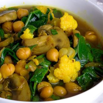 A bowl of spinach and chickpea soup with turmeric.