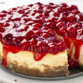 A homemade cherry cheesecake with a slice missing. A divine dessert.