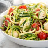 A bowl of a delicious and healthy zucchini noodle caprese salad.