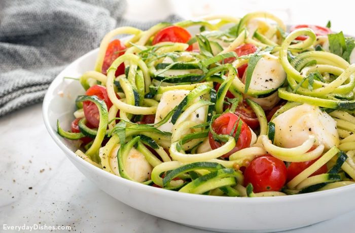 A bowl of a delicious and healthy zucchini noodle caprese salad.