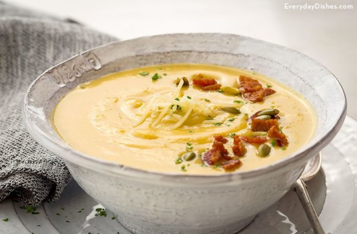 A bowl of roasted acorn squash soup with bacon and pumpkin seeds