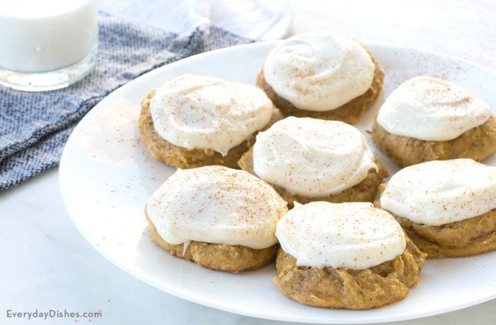 A plate of pumpkin cookies, iced with cream cheese frosting.