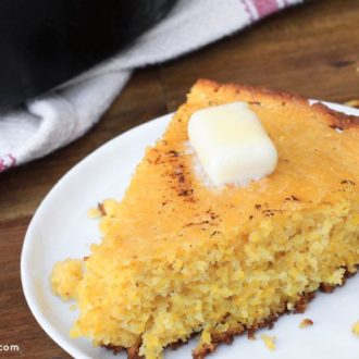 A piece of easy skillet cornbread topped with a dollop of butter.