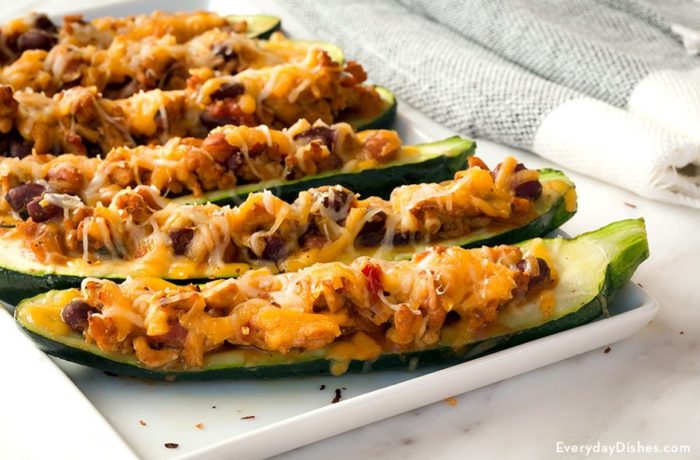 A plate with a fresh batch of chili cheese zucchini boats, a great party appetizer.