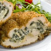 A plate with a delicious spinach artichoke dip stuffed chicken, a great dinner.