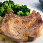 A plate with traditional pork chops, mashed potatoes, and broccoli; the perfect dinner.