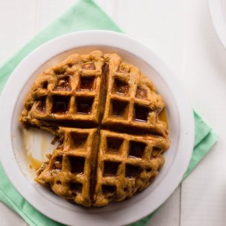 A homemade matcha waffle that's covered in syrup and being enjoyed for breakfast.