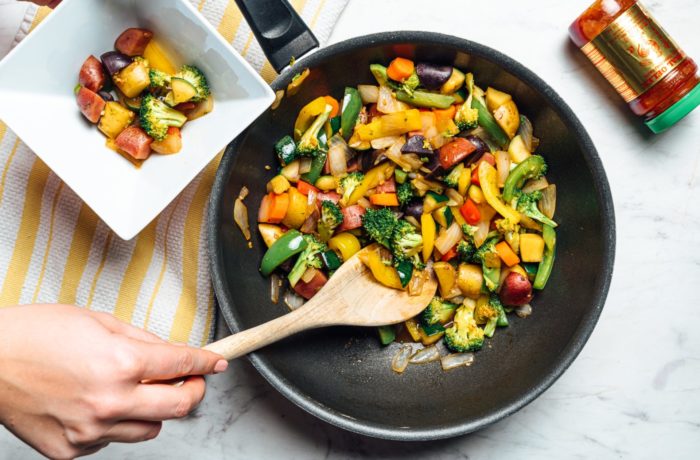 A Whole 30 vegan veggie stir fry, being served out of a skillet.