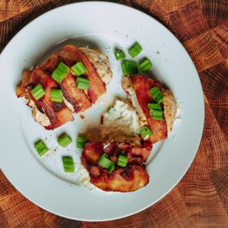 A delicious plate of bacon wrapped stuffed chicken that's ready to enjoy for dinner.