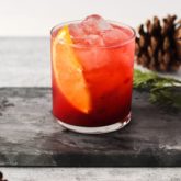 A glass full of a refreshing cranberry orange vodka cocktail