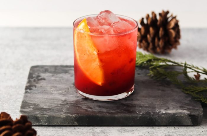 A glass full of a refreshing cranberry orange vodka cocktail