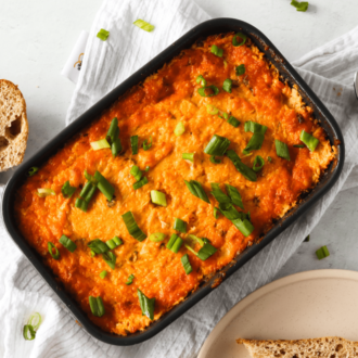 A freshly made pan full of the best buffalo chicken dip, on the table and ready to serve.