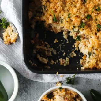 A delicious keto jalapeño popper casserole with one serving taken out of the pan.