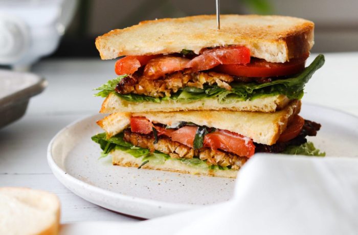 A delicious vegan BLT sandwich, sliced in half
