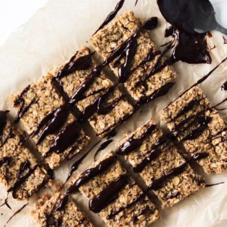 Some healthy, homemade granola bars, covered in chocolate and ready to enjoy.