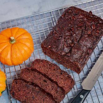 A loaf of chocolate pumpkin bread, sliced and ready to eat.