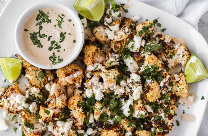 grilled cauliflower garnished with lime wedges.
