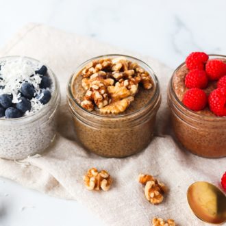 Chia seed pudding in three containers with different garnishes, all ready to eat.