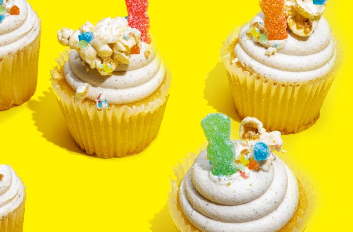 Cupcakes topped with Sour Patch Kids and candy pop.