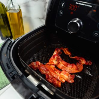 Delicious, crispy bacon being cooked in an air fryer.