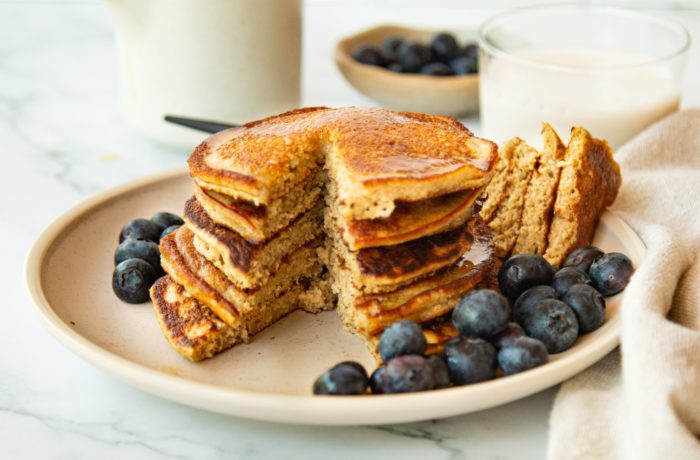A plate of flourless protein blender pancakes with blueberries. A great high protein breakfast for weight loss.