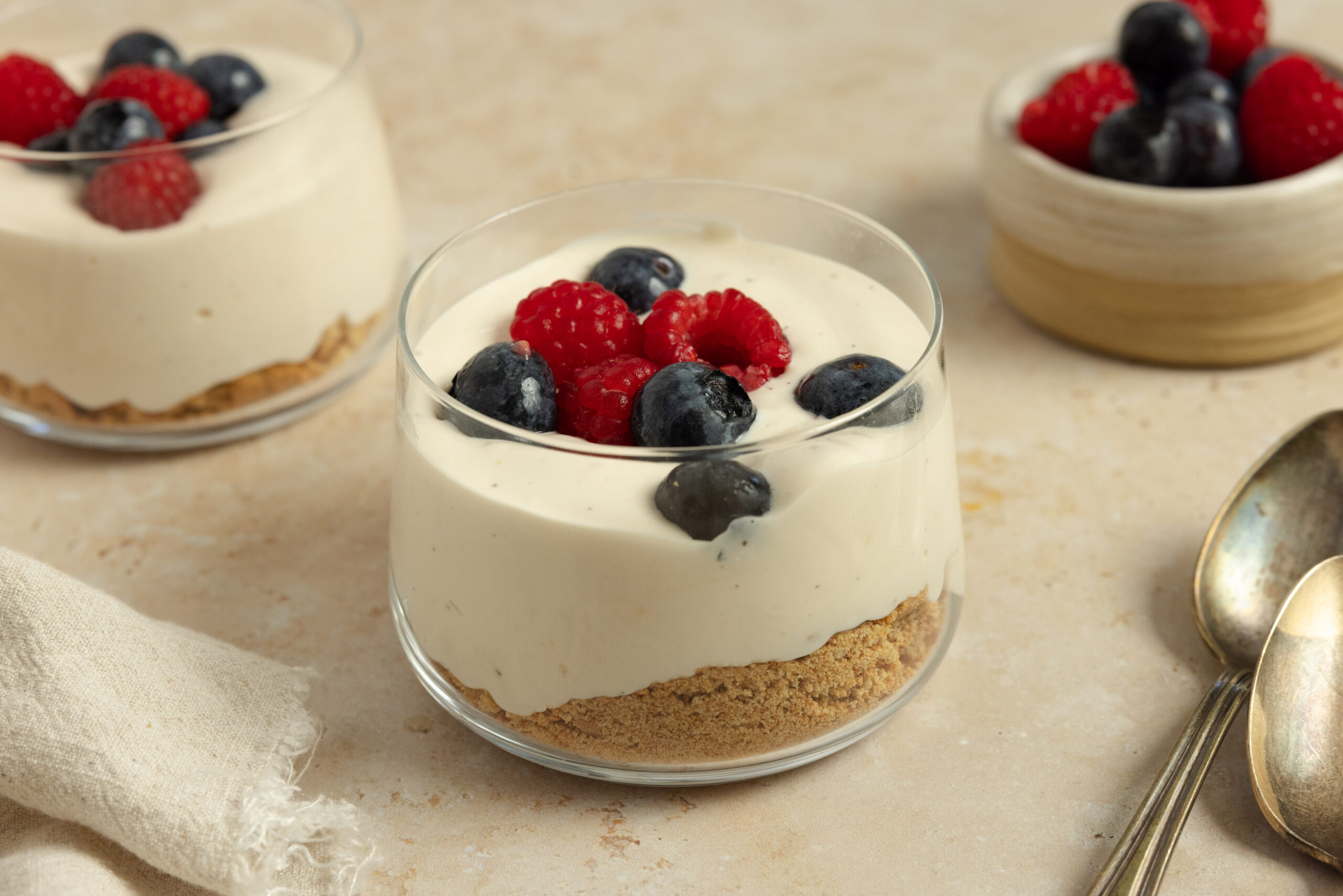 Flat lay of ingredients for high protein cheesecake cups including yogurt, cottage cheese, and berries.